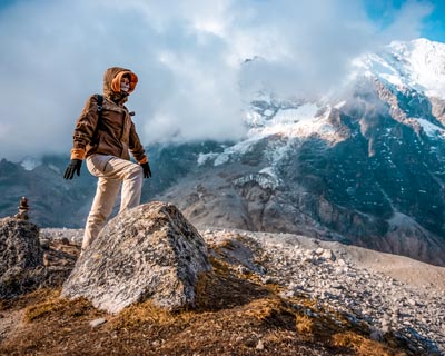 Tourist on the Salkantay Pass with the snow-capped mountain in the background